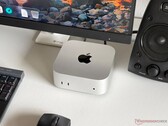 Komputer Apple M6 Mac mini na biurku w zestawie do gier wraz z monitorem, klawiaturą, myszą i głośnikiem.