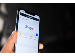 Zdjęcie dłoni trzymającej smartfon z otwartą na ekranie stroną główną wyszukiwarki Google. (Źródło zdjęcia: Solen Feyissa na Flickr)