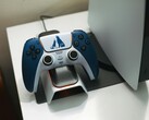 Niestandardowy kontroler DualSense o tematyce God of War spoczywający na stacji ładującej przed konsolą PlayStation 5. (Źródło zdjęcia: FOX ^.ᆽ.^= ∫)