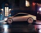 Kabina Tesli zaparkowana na mokrej ulicy miasta w nocy, charakteryzująca się eleganckim, futurystycznym wyglądem z zakrytymi kołami. (Źródło zdjęcia: Tesla)