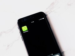 Smartfon na białym stole z wyświetloną aplikacją WhatsApp