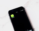 Smartfon na białym stole z wyświetloną aplikacją WhatsApp