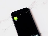 Smartfon na białym stole z wyświetloną aplikacją WhatsApp