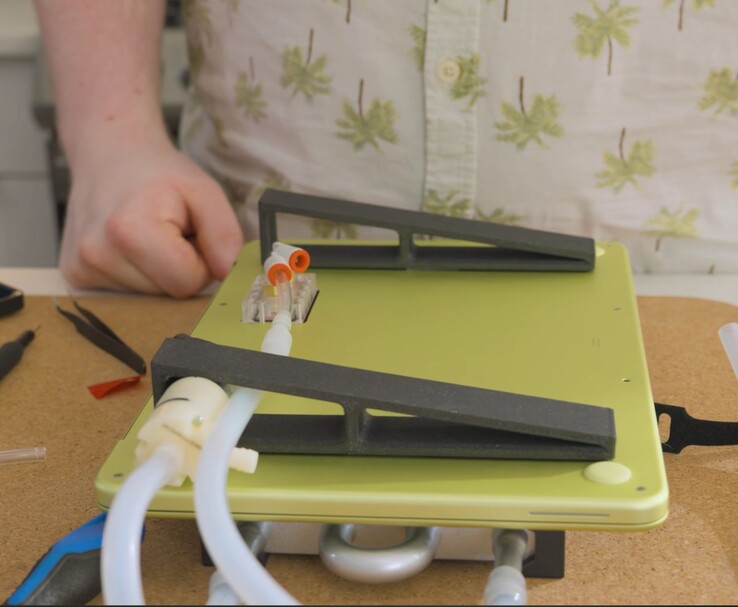 Zmodyfikowany MacBook Neo z zewnętrzną pompą i rurkami do chłodzenia cieczą DIY