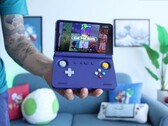 Russ z Retro Game Corps trzymający ręczną konsolę do gier Retroid Pocket Flip 2 w kolorze fioletowym, z ekranem wyświetlającym interfejs emulatora Sega Genesis. (Źródło obrazu: Retro Game Corps na YouTube)
