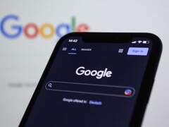 Smartfon wyświetlający stronę wyszukiwarki Google na tle ekranu z logo Google