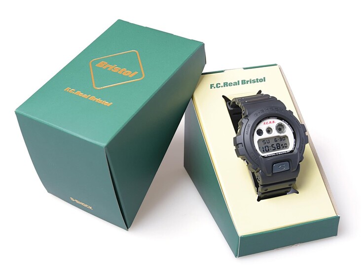 Model Casio G-Shock x F.C. Real Bristol DW-6900 umieszczony w zielonym pudełku z logo obu marek, a obok niego znajduje się pasująca do niego zewnętrzna osłona.