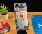 Przezroczysty iPhone Air pokazujący wewnętrzne komponenty i miedzianą cewkę ładującą na drewnianym biurku (źródło obrazu: Phone Repair Guru via YouTube)