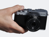 Kompaktowy aparat z wymiennymi obiektywami Fujifilm X-E4 w dłoni