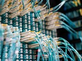 Niebieskie kable światłowodowe z białymi złączami podłączone do panelu krosowego w centrum danych