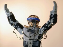 Humanoidalny robot z rękami w powietrzu (źródło zdjęcia: Adam Lukomski via Unsplash; przycięte)