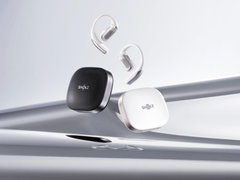 Shokz OpenFit Pro (z etui), na zdjęciu na stylizowanym srebrnym tle. (Źródło zdjęcia: Shokz)