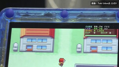Zbliżenie na przezroczystą niebieską konsolę przenośną FPGBA SP z uruchomioną grą Pokémon i widocznym licznikiem 59.74 FPS.