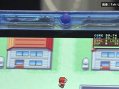 Zbliżenie na przezroczystą niebieską konsolę przenośną FPGBA SP z uruchomioną grą Pokémon i widocznym licznikiem 59.74 FPS.