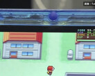 Zbliżenie na przezroczystą niebieską konsolę przenośną FPGBA SP z uruchomioną grą Pokémon i widocznym licznikiem 59.74 FPS.