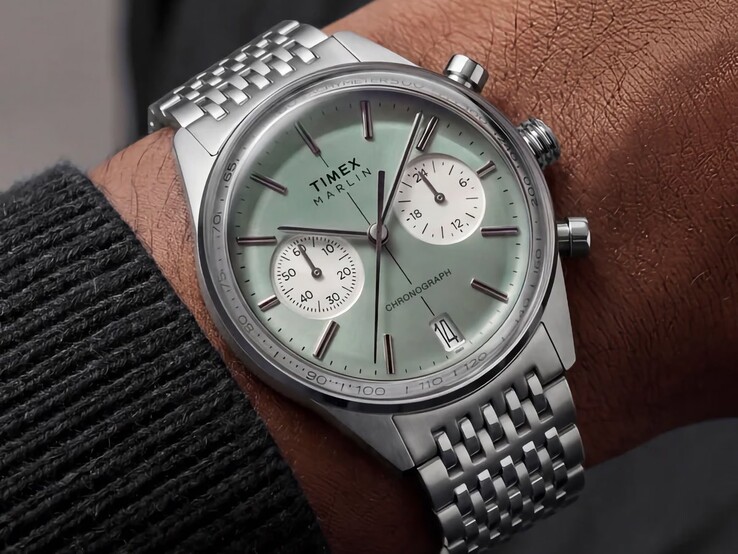 Chronograf Timex Marlin Jet z tarczą w kolorze szałwiowej zieleni i bransoletą ze stali nierdzewnej na nadgarstku, ukazujący wypukłe szkło oraz zaokrąglony, retrofuturystyczny profil koperty.