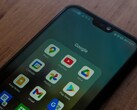 Smartfon na drewnianym biurku z otwartym folderem aplikacji Google