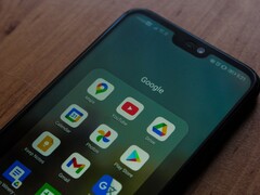 Smartfon na drewnianym biurku z otwartym folderem aplikacji Google