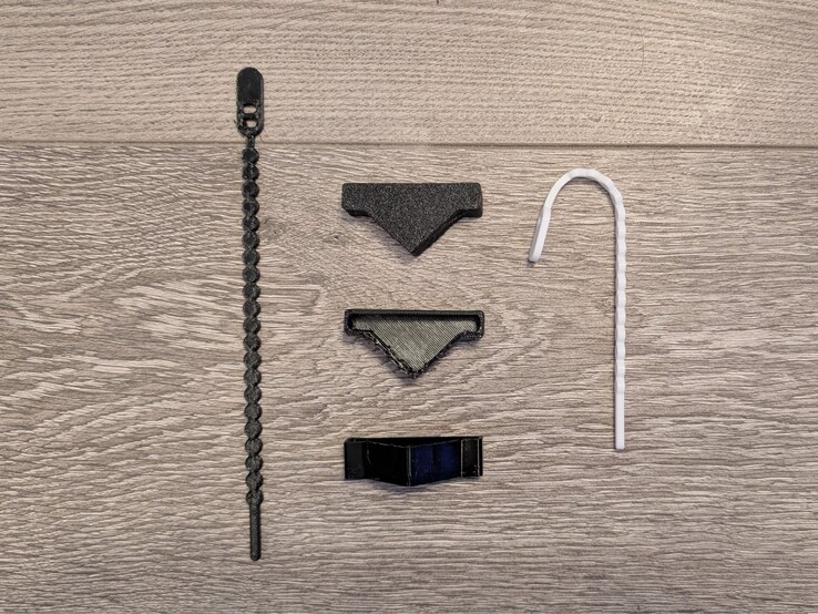 Opaski zaciskowe z czarnego i białego TPU (wykonane przez Extrutim na Printables) oraz niestandardowe narożniki do systemu montażowego z czarnego TPU.