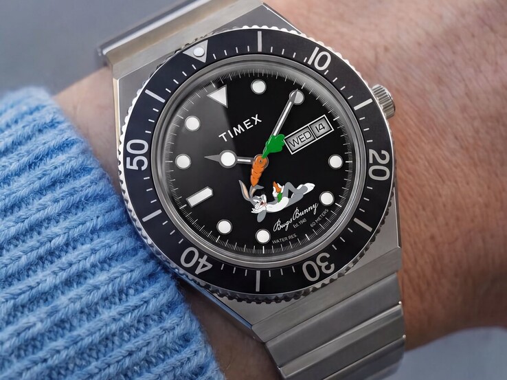 Zegarek Timex Looney Tunes x M79 Automatic noszony na nadgarstku, z czarną tarczą przedstawiającą Królika Bugsa, wskazówką sekundową w kształcie marchewki, wskazaniem dnia i daty oraz czarną obrotową lunetą.