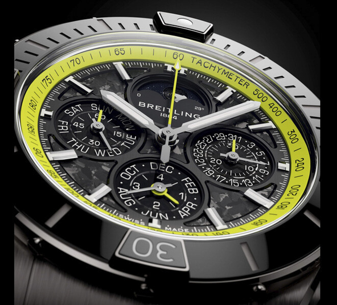Zbliżenie na zegarek Breitling Super Chronomat B19 44 Perpetual Calendar Chronograph ukazujące tarczę z włókna węglowego, subtarcze kalendarza, wskazówki w srebrnym kolorze i limonkowozieloną skalę tachymetru.
