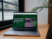 Laptop na biurku przy oknie, z otwartą na ekranie stroną internetową OpenAI ChatGPT
