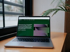 Laptop na biurku przy oknie, z otwartą na ekranie stroną internetową OpenAI ChatGPT