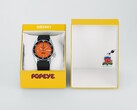Zegarek automatyczny Seiko 5 Sports x Popeye HDB013 z pomarańczową tarczą, umieszczony obok limitowanej edycji żółtego pudełka prezentacyjnego.