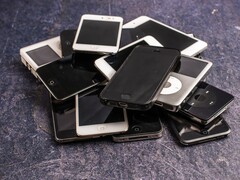 Stos wycofanych z użytku smartfonów na szarej powierzchni