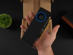 Osoba trzymająca niskoprofilowy procesor graficzny Intel Arc Pro B50 do stacji roboczych z chłodnicą w stylu dmuchawy, pokazany na tle opakowania. (Źródło zdjęcia: ETA Prime via YouTube)