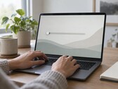 Ręce na klawiaturze laptopa, suwak po lewej stronie ekranu